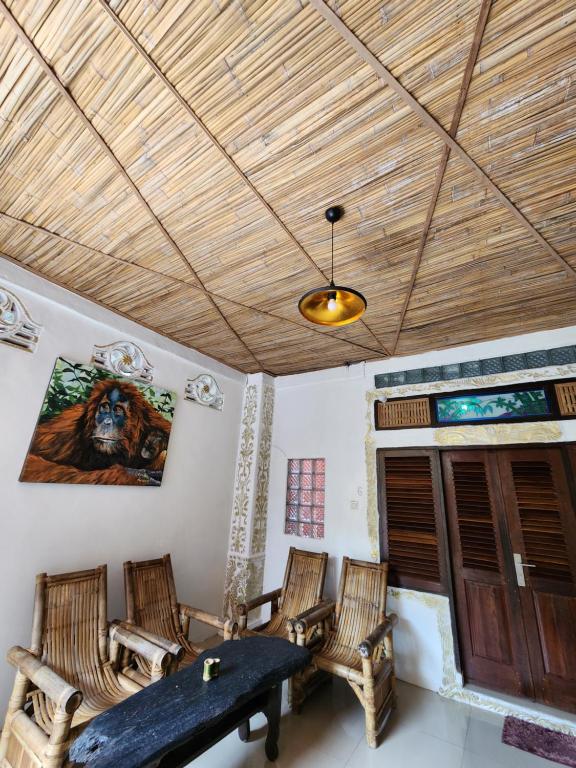 a room with chairs and a table and a ceiling at Jungle Inn Bukit lawang in Bukit Lawang