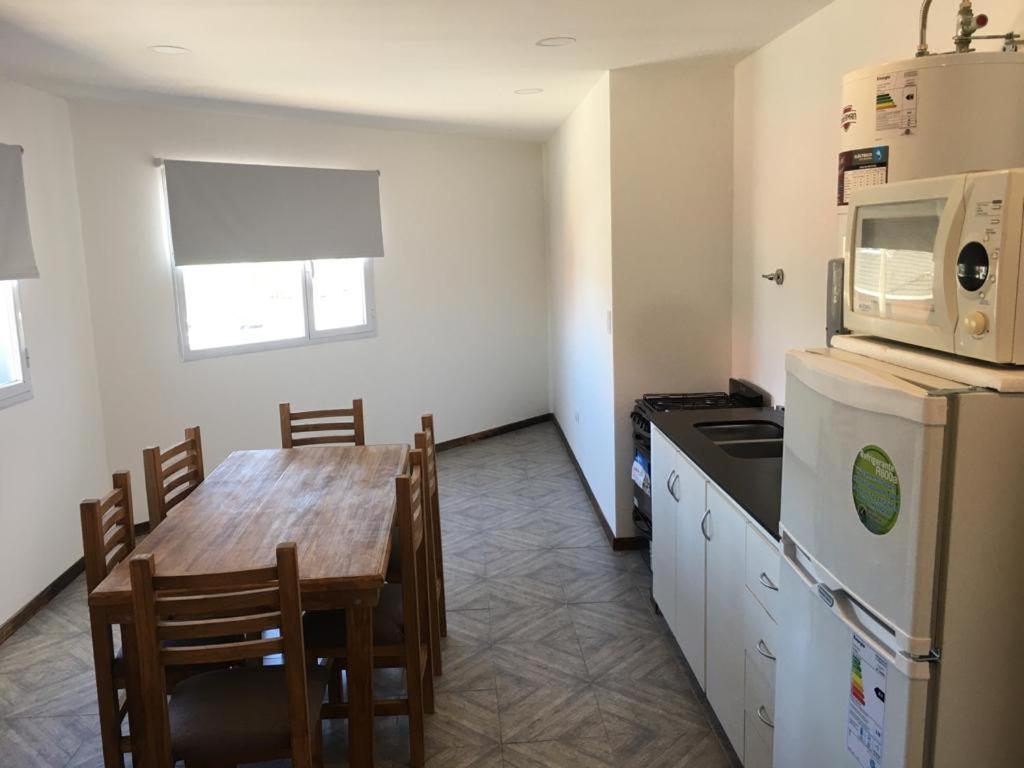 cocina con mesa de comedor y microondas en Departamento nuevo a estrenar en Necochea