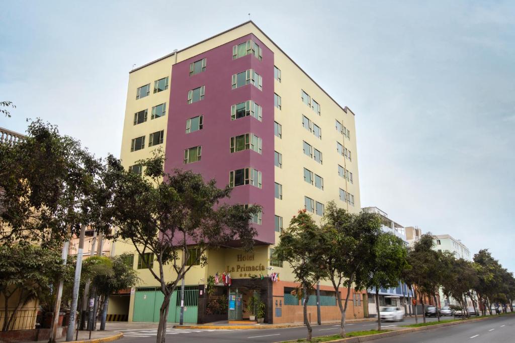 a pink and yellow building on a city street at La Primacía in Lima