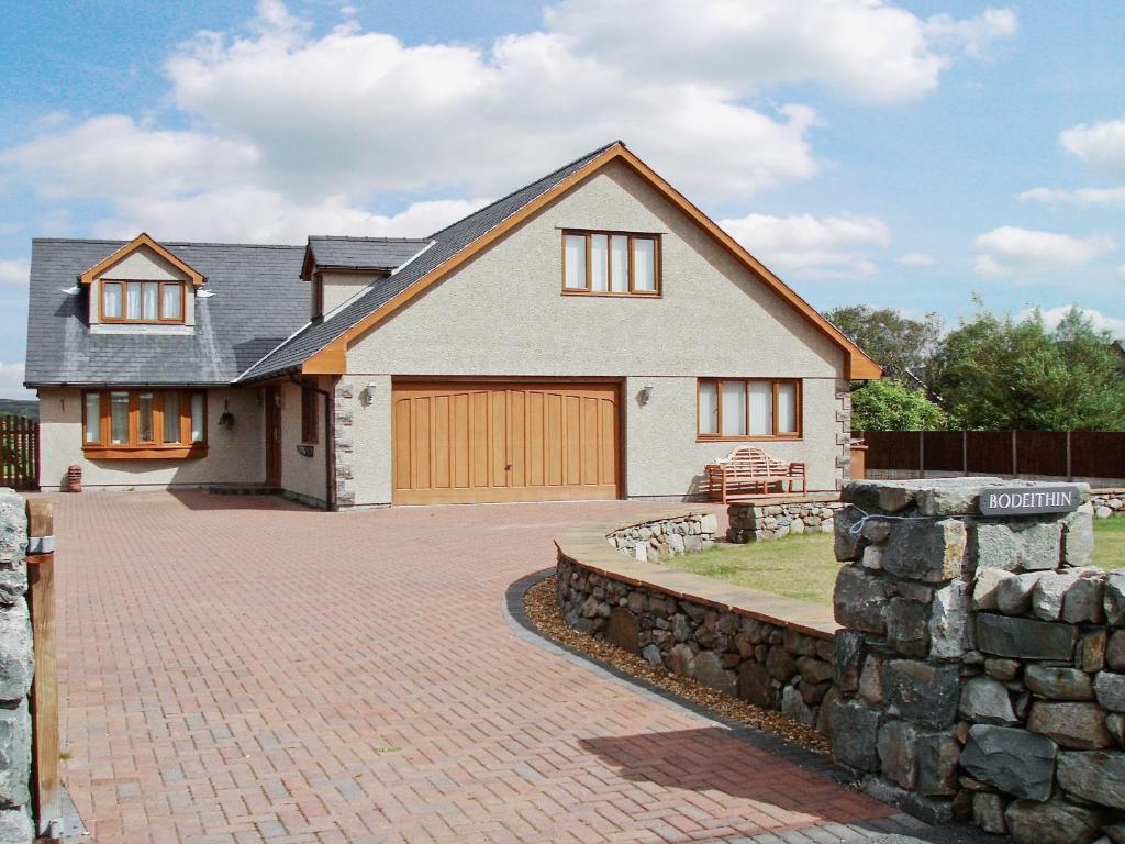 a house with a brick driveway and a stone wall at Bod Eithin in Harlech