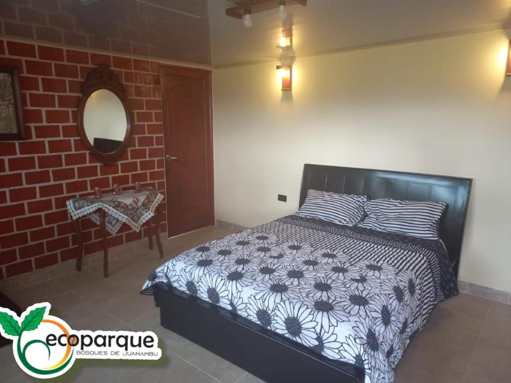 a bedroom with a bed and a brick wall at Ecoparque in Buesaco
