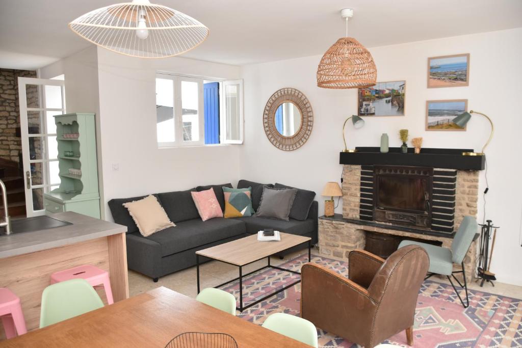 un salon avec un canapé et une cheminée dans l'établissement DOLUS, Maison à 10 min. de la plage!, à Dolus-d'Oléron