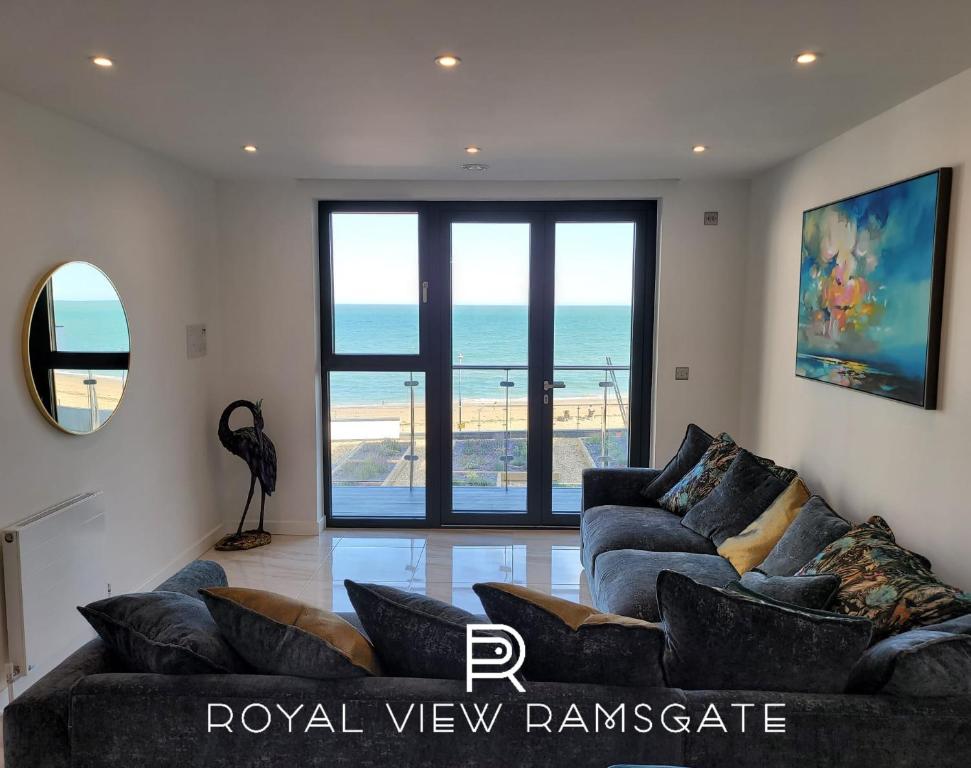 a living room with couches and a view of the ocean at Royal View in Ramsgate