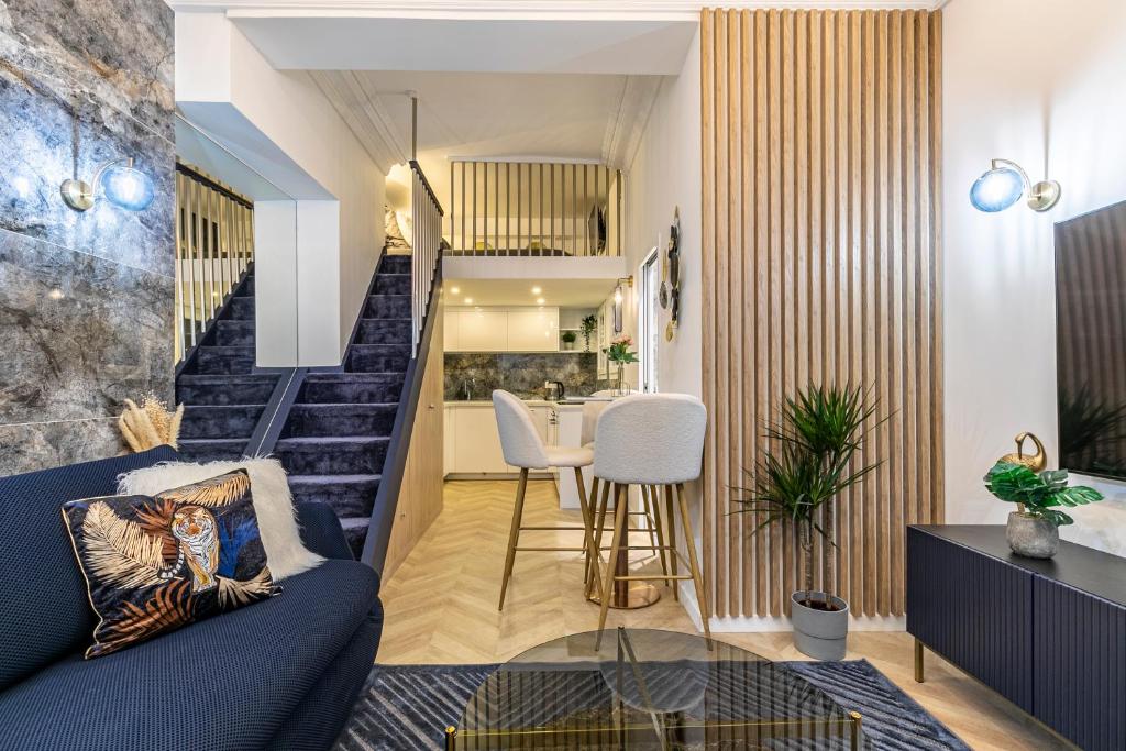 - un salon avec un canapé bleu et des escaliers dans l'établissement Le studio de l'île, à Paris