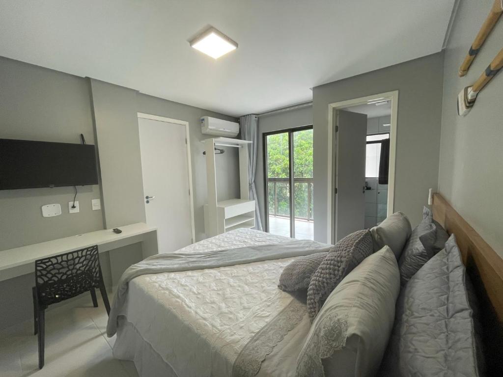 Dormitorio con cama, escritorio y TV en Apartamento na Praia do Francês en Praia do Frances