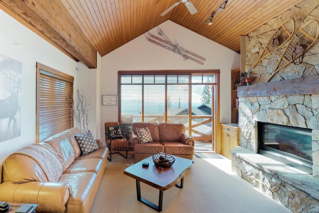 Una sala de estar con un sofá y una chimenea. en Rockridge 375 Snow Escape, en Big White