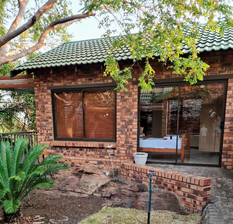 a brick house with a bed in the window at La Casa Greeff Guesthouse in Pretoria