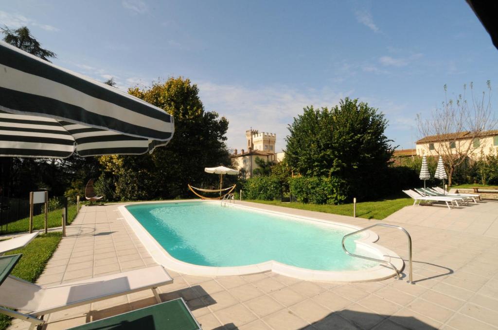 a swimming pool with an umbrella and chairs at Villa Torricelli Scarperia - Il Giardinetto Residence in Scarperia