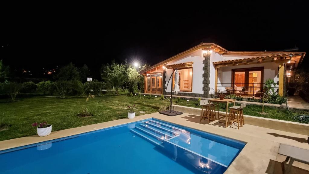 a villa with a swimming pool at night at Huandoy Lodge - Huaraz in Yungay