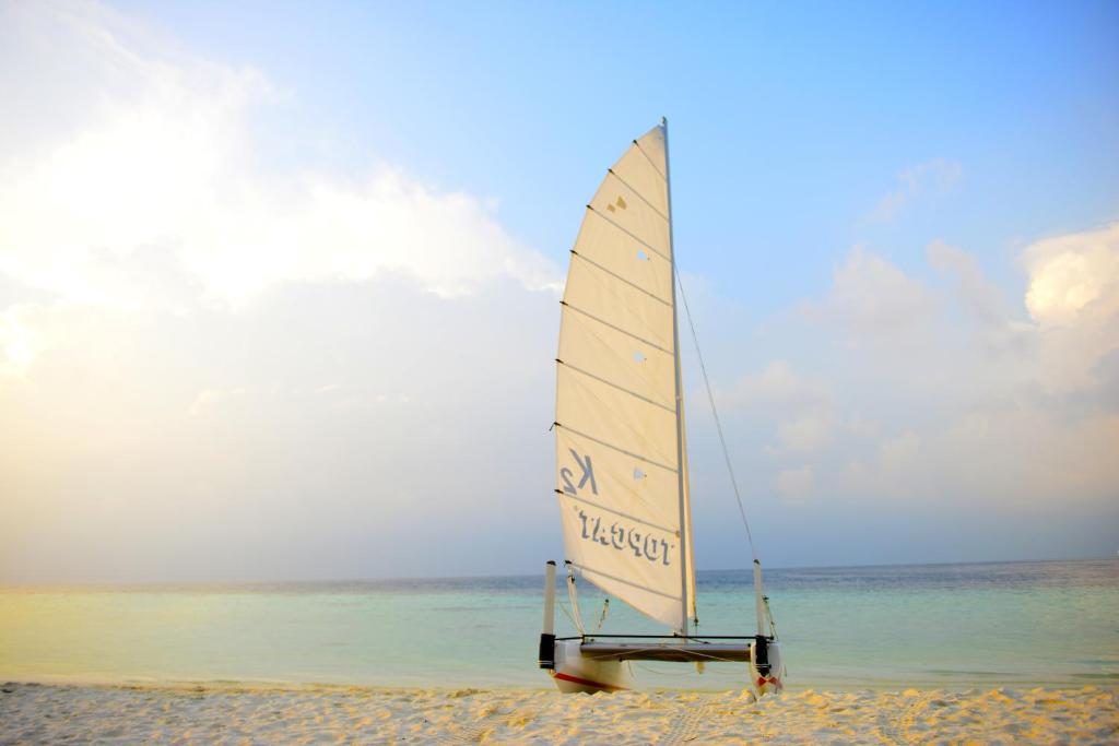 a sail boat sitting on the beach at Biyadhoo Island Resort in Biyadhoo