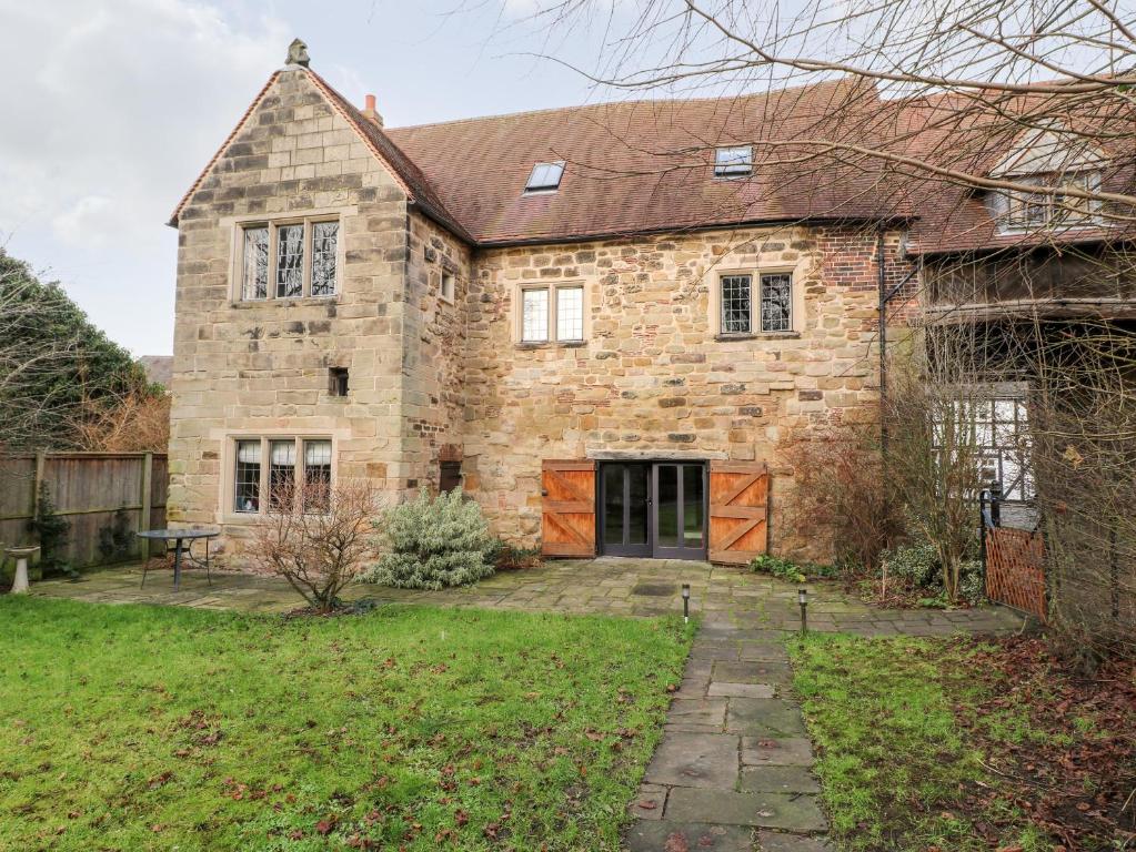 a large stone house with a yard at Gatehouse Croft in Newton Regis
