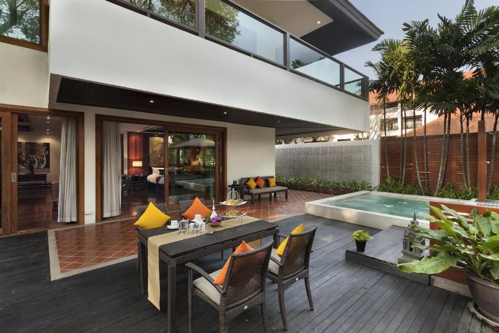 A private outdoor terrace with dining furniture and a small raised plunge pool.