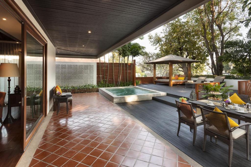 A private-looking outdoor pool terrace with shaded dining and a separate raised spa.
