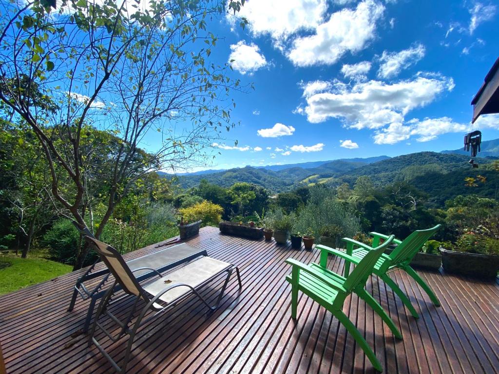 3 sillas y una mesa en una terraza con vistas en Uma Casa Sobre o Mundo, en Santo Antônio do Pinhal