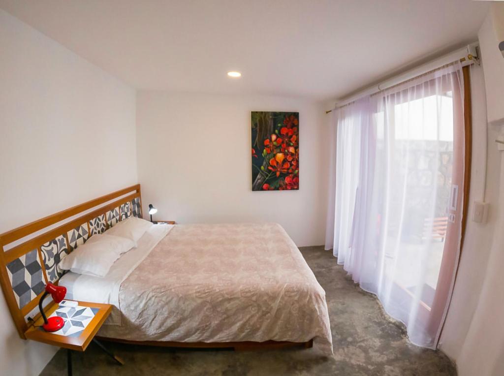 ein Schlafzimmer mit einem großen Bett und einem Fenster in der Unterkunft La K-leta Boutique Guesthouse in Puerto Ayora