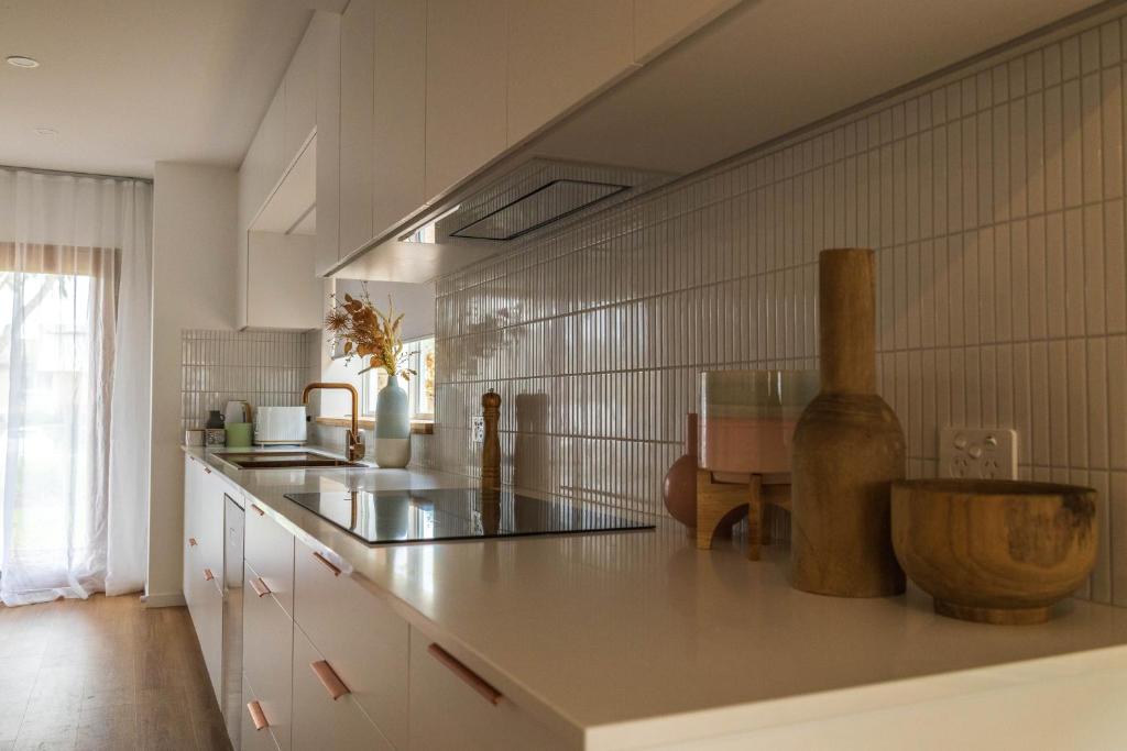 een keuken met witte kasten en een aanrecht bij Bellvilla Suites in Merimbula