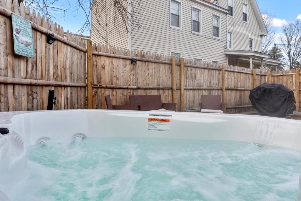 einen Whirlpool in einem Garten neben einem Zaun in der Unterkunft NEW!! Lovely unit w/ PRIVATE Hot Tub and patio! in Laconia