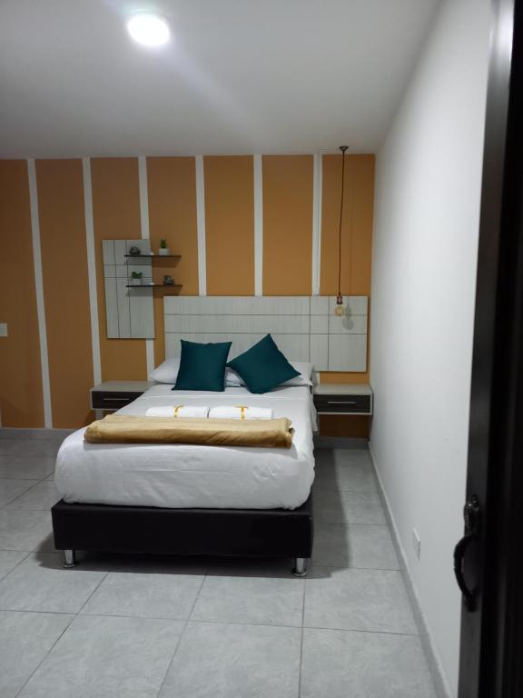 1 dormitorio con 1 cama grande con almohadas azules en Aparta-Estudio, en Medellín