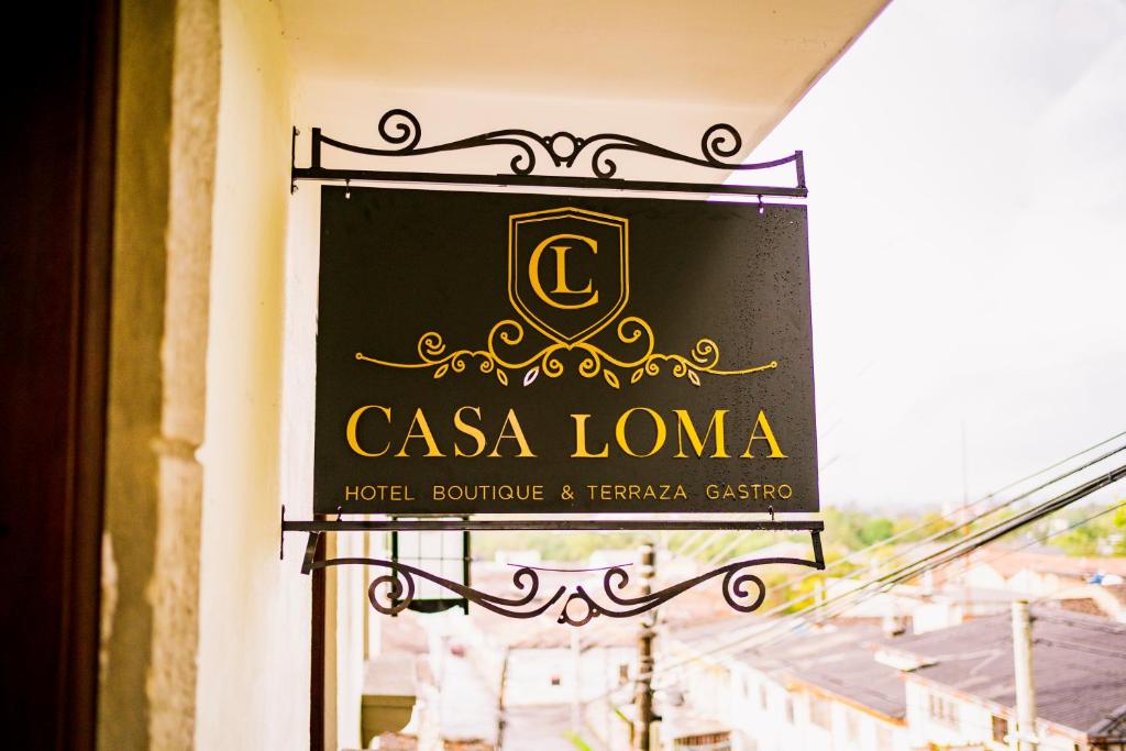 um sinal para uma casa loma ao lado de um edifício em CASA LOMA HOTEL BOUTIQUE & TERRAZA GASTRO em Popayán