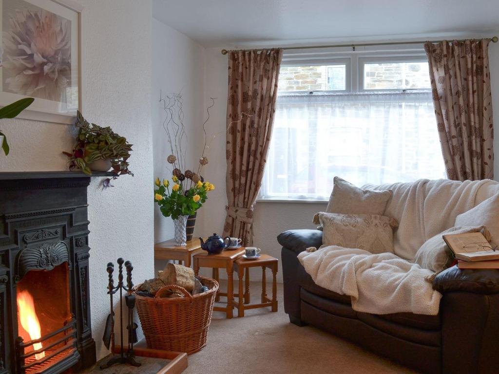 a living room with a couch and a fireplace at Bridgend Cottage in Lostwithiel