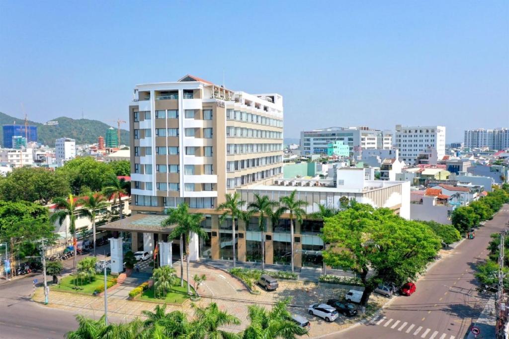 ein hohes weißes Gebäude in einer Stadtstraße in der Unterkunft Saigon Quy Nhon Hotel in Quy Nhon