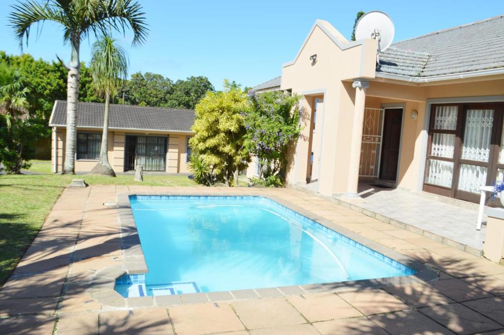 a swimming pool in front of a house at Sindy's Chalets in Margate