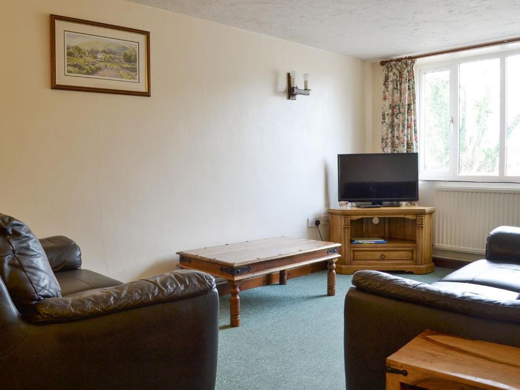a living room with two couches and a tv at Stable Cottage 6 - Ukc3745 in Bawdeswell