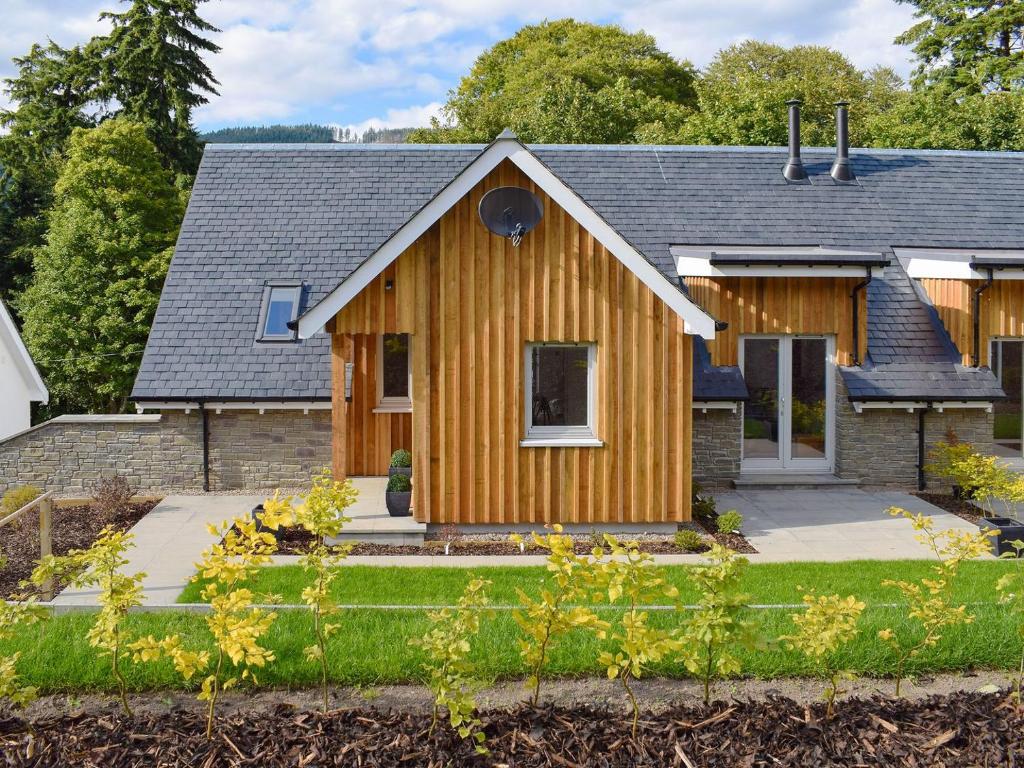 uma casa com um exterior de madeira em Kenmore Lodge em Kenmore