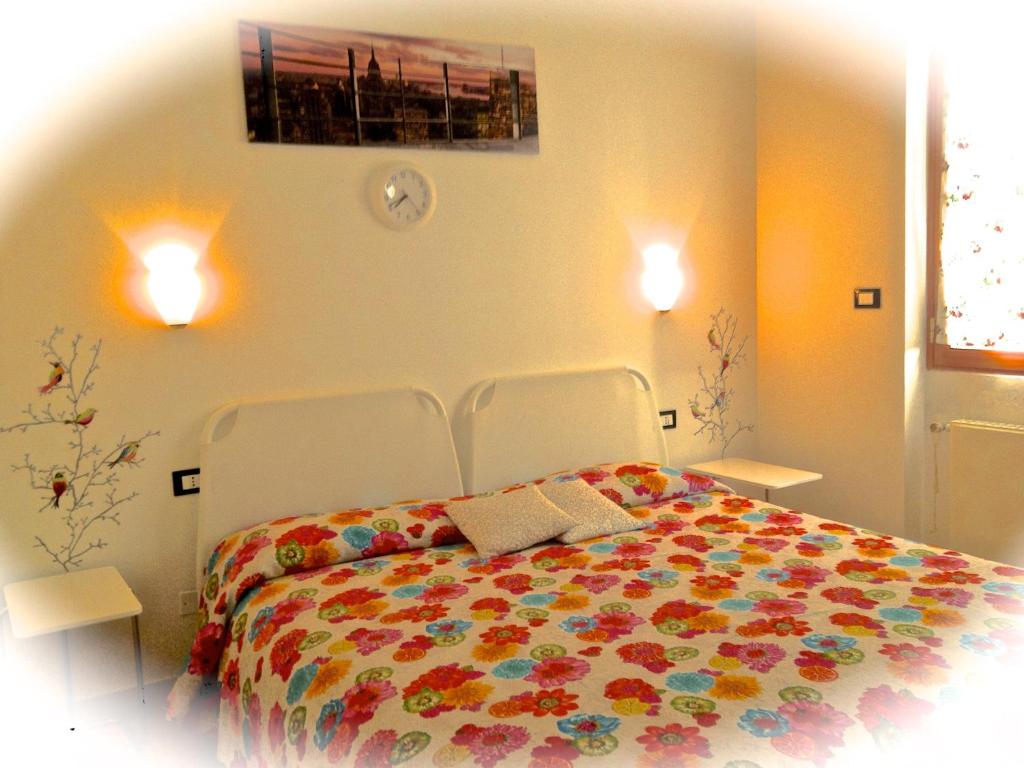 ブルゲーリオにあるTop Suit Centro - Guest houseのベッドルーム1室(カラフルな毛布付きのベッド1台付)