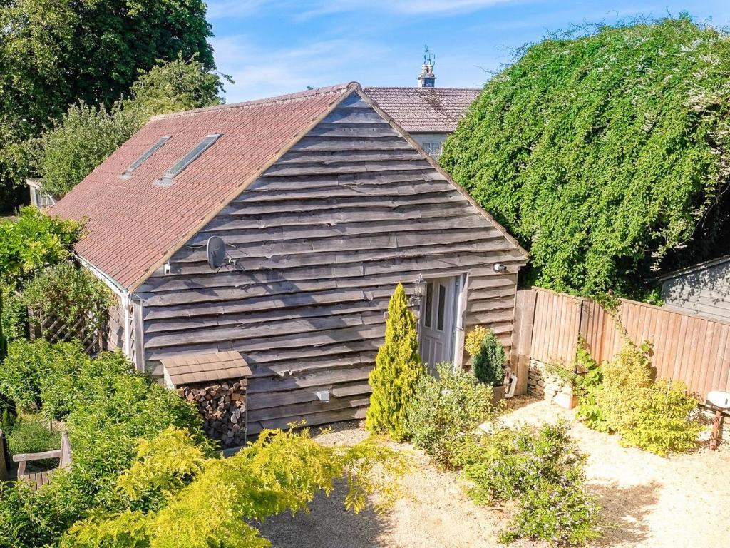 een oud houten huis met een dak bij Maple Lodge in Corsham