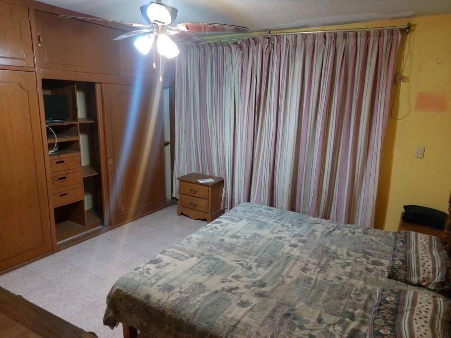 a bedroom with a bed and a ceiling fan at Amplia y Hogareña Casa in Aguascalientes