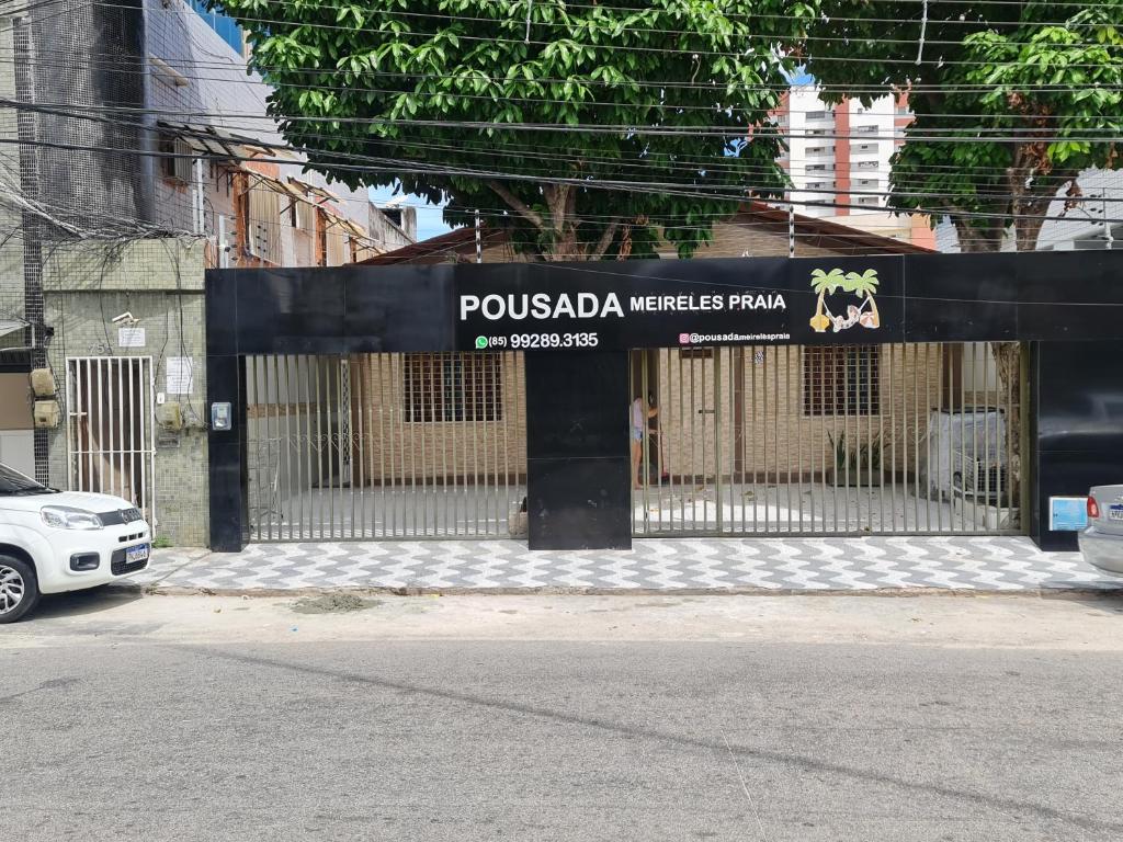 une porte devant un bâtiment avec un panneau dans l'établissement Pousada Meireles Praia, à Fortaleza
