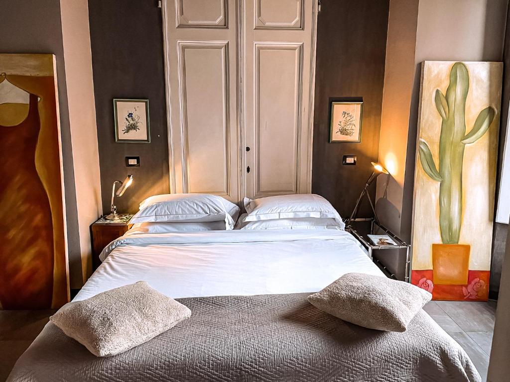 ein Schlafzimmer mit einem großen Bett mit zwei Kissen darauf in der Unterkunft Acacia Firenze Apartments Cumino-Cannella-Curry in Florenz
