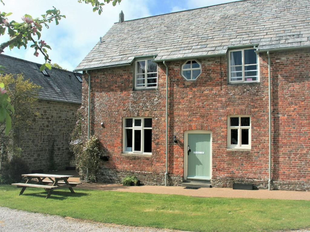 a brick building with a picnic table in front of it at The Mews - Ukc4125 in Bridgerule