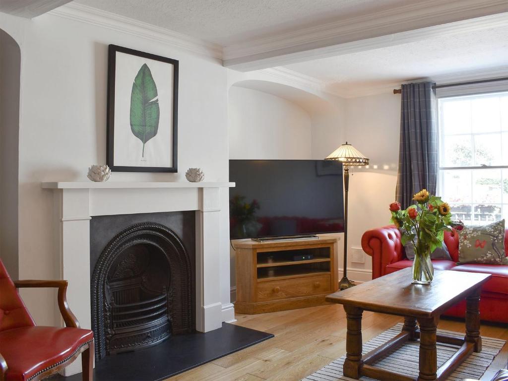 a living room with a fireplace and a tv at The Townhouse in Wimborne Minster