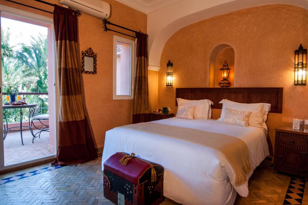 a bedroom with a large bed and a large window at Double room in a charming villa in the heart of Marrakech palm grove in Marrakesh