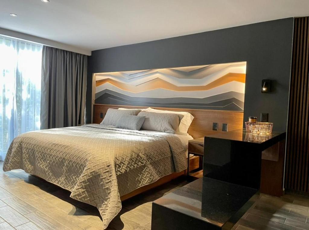 a bedroom with a bed and a painting on the wall at BUSINESS SUITES MINE in Mexico City