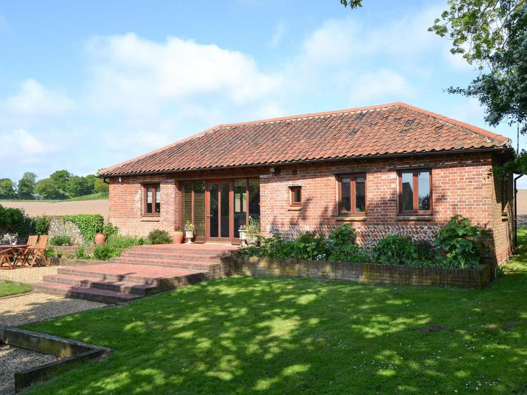 a brick house with a lawn in front of it at Elm Tree Barn in Felmingham