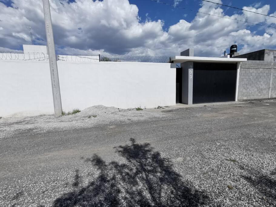 a white building with a door on the side of a road at ESTANCIA LA CARRETA in Matehuala