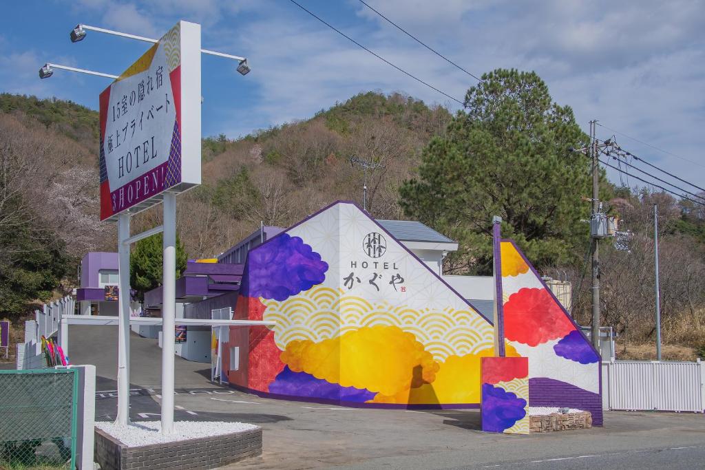 a building with a sign in a parking lot at Hotel Kaguya in Himeji