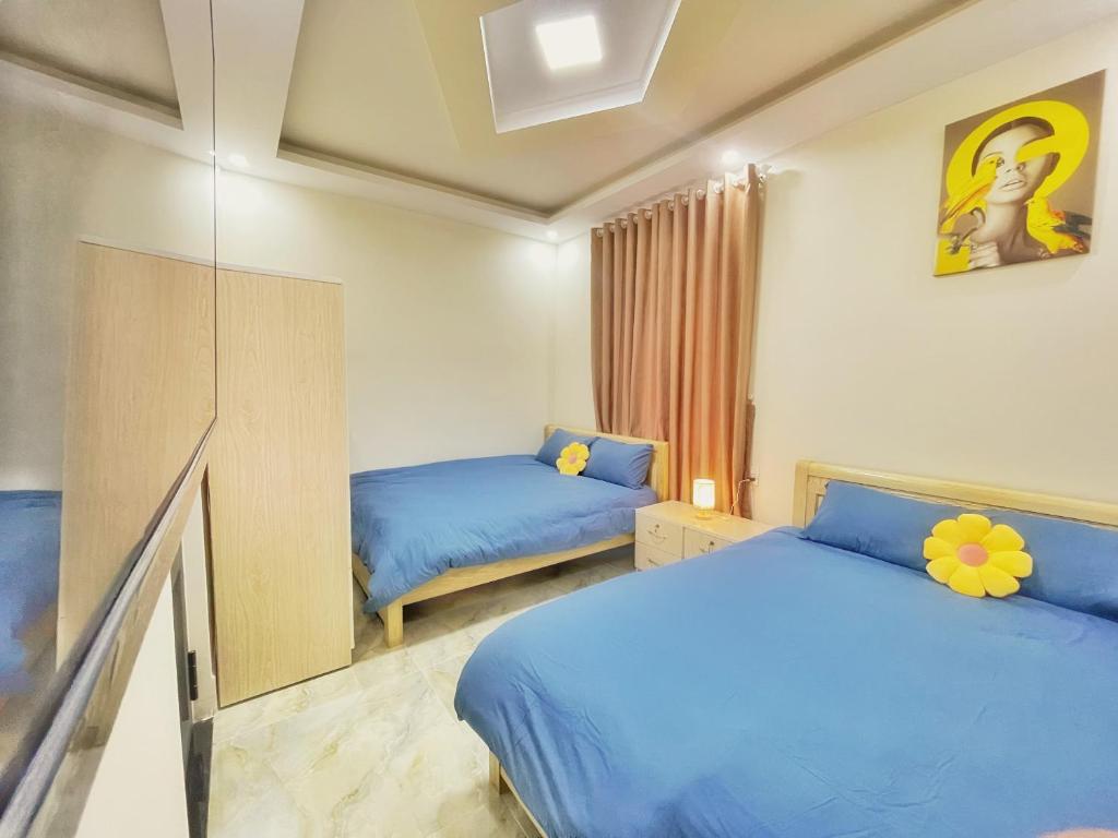 a bedroom with two beds and a mirror at Vĩnh Hà Motel in Trai Mat