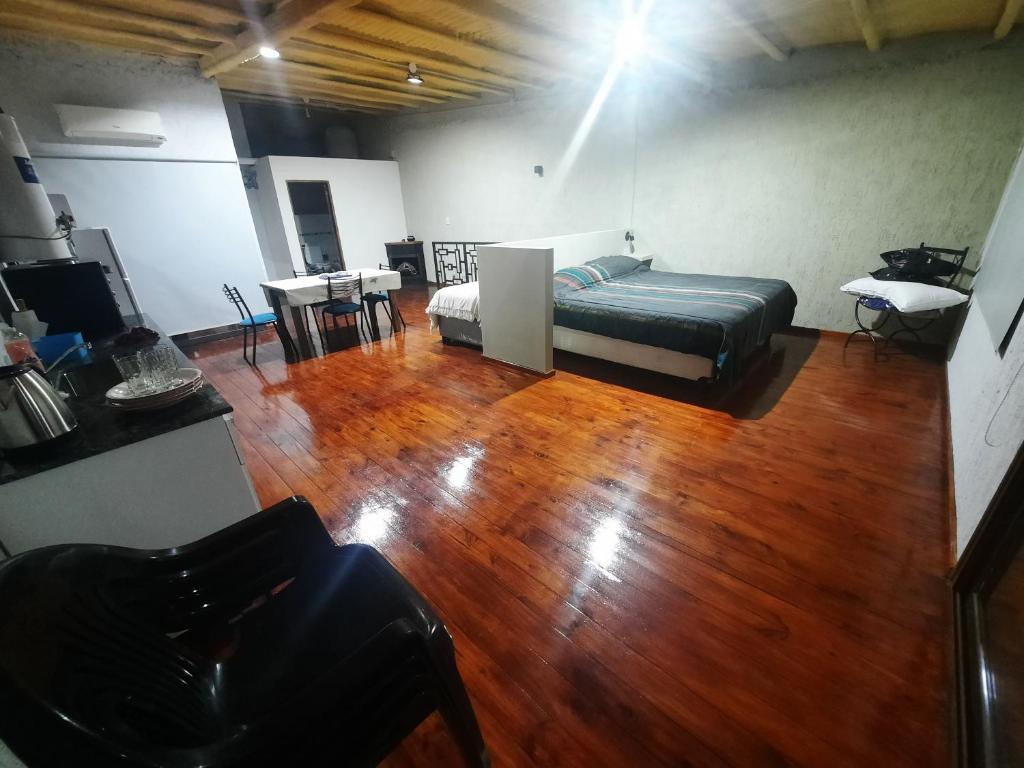 1 dormitorio con 1 cama y suelo de madera en CALUANABRU en Malargüe