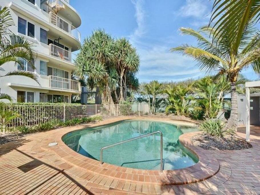 a swimming pool in front of a building at Kawana Waters Ocean Front Unit- Sunshine Coast in Buddina