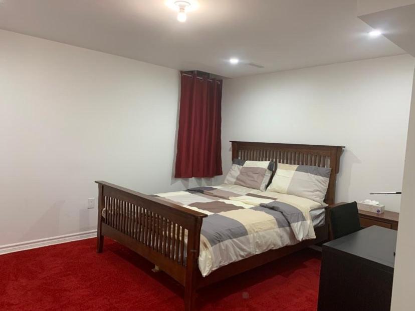 a bedroom with a bed and a red carpet at Guest House Room No 01 in Mississauga