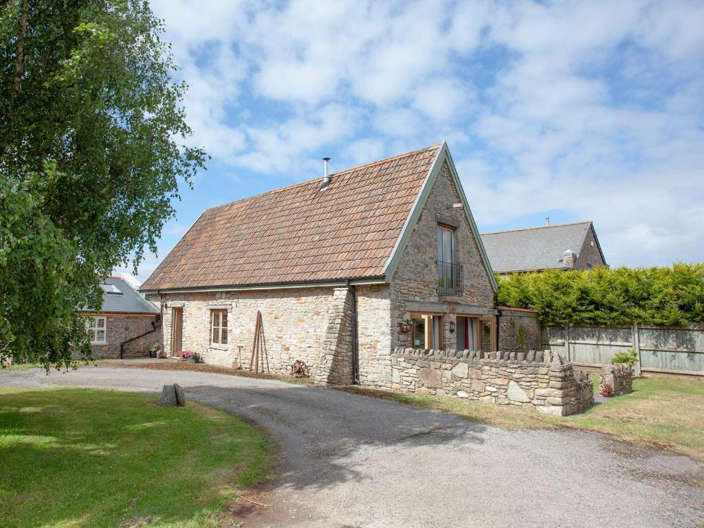 ein Steinhaus mit braunem Dach in der Unterkunft The Old Forge in Bleadon