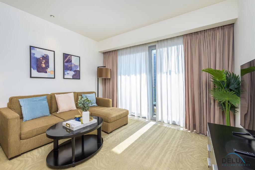 uma sala de estar com um sofá e uma mesa em Ornate 1BR in The Address Residences Dubai Marina by Deluxe Holiday Homes em Dubai