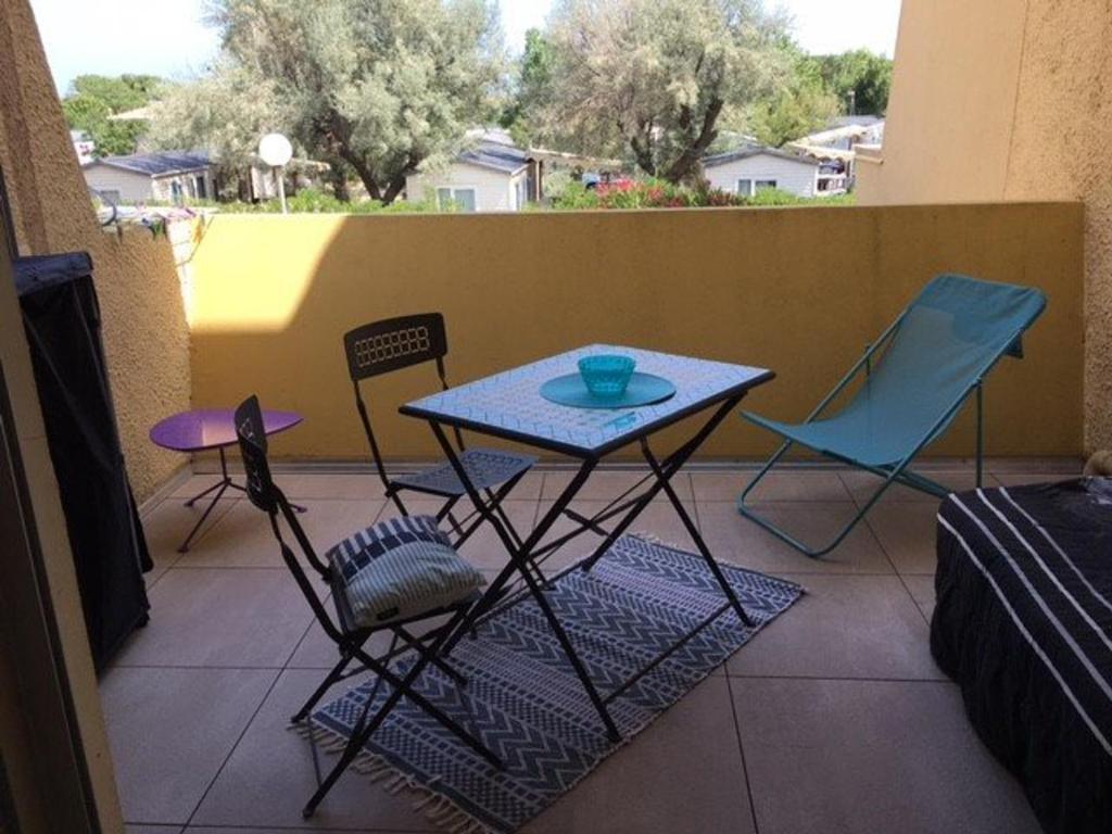 un patio avec une table et des chaises sur un balcon dans l'établissement Studio Grand Confort, 4 Couchages, Accès Direct Plage - FR-1-326-593, à Marseillan