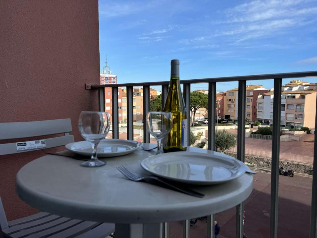 stół z kieliszkami i butelką wina na balkonie w obiekcie Studio Centre avec Piscine, Balcon et Proximité Plage, 2 Personnes - FR-1-702-3 w Cap d'Agde