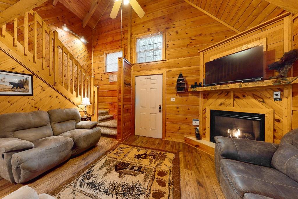 una sala de estar con sofás y una chimenea en una cabaña en Misty Mountain Cabin en Gatlinburg