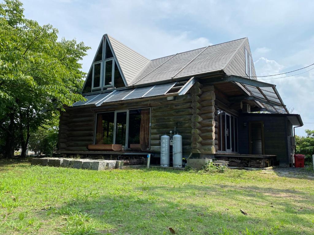 una pequeña casa de madera con techo de estaño en BAYMARINAログハウス, en Sakaide
